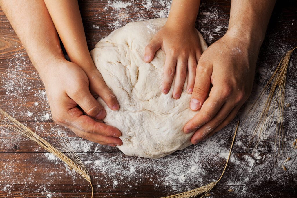 Kneading dough, father and child baking bread together
