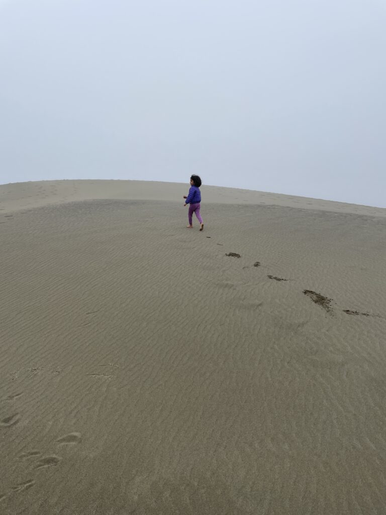 A child walks in the sand searching for a meaningful life
