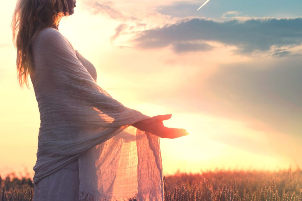 Woman with shawl, opening hands to sky in acceptance