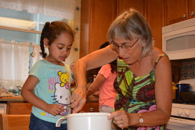 Woman cooking with grandchildren - helps with a meaningful life