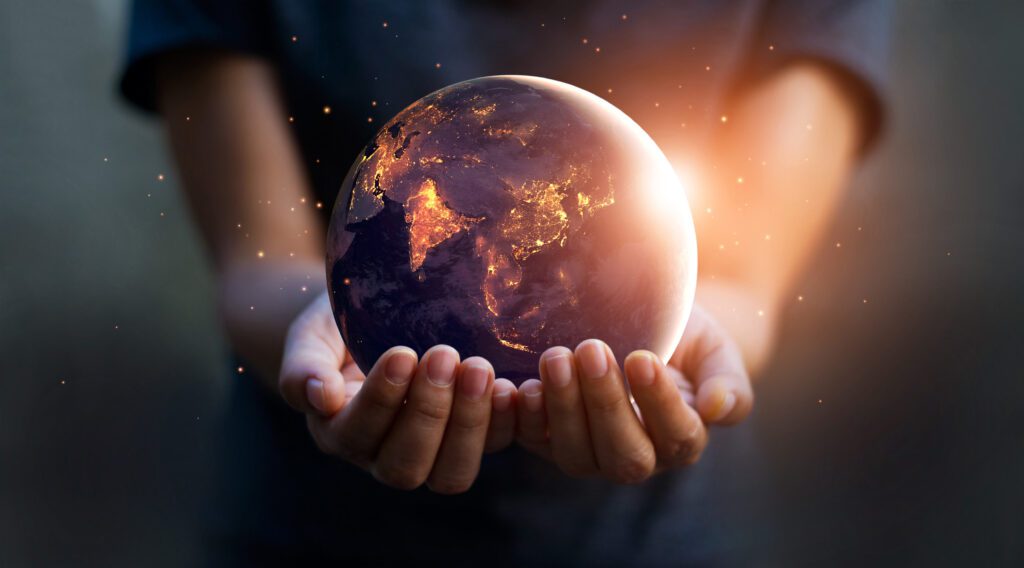 Artistic photo of hands holding a glowing earth globe.