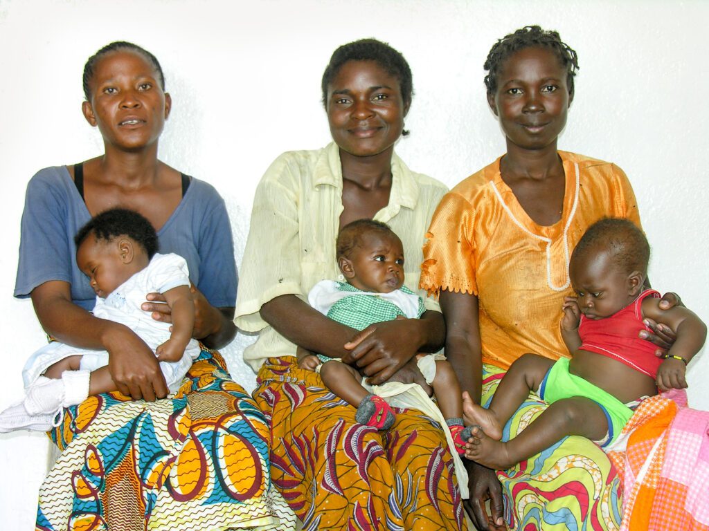 Group of women holding babies in Africa:  fostering social responsibility